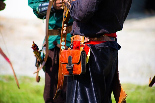 城の領土に弓を持った中世の服を着た人々