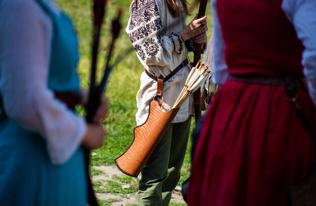 People in medieval clothes with bows on the territory of the castle