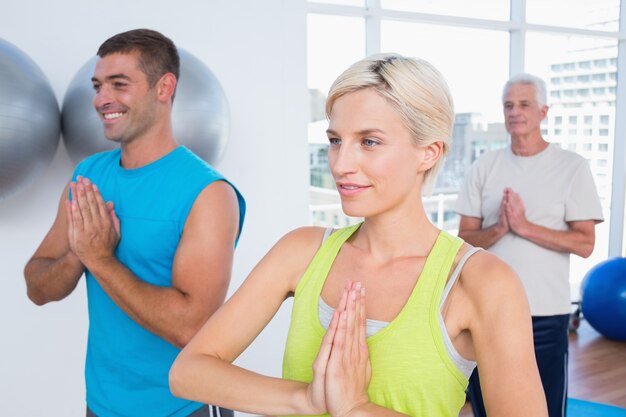 Foto le persone che meditano nel fitness club