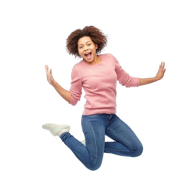 people, motion and action concept - happy african american young woman jumping over white