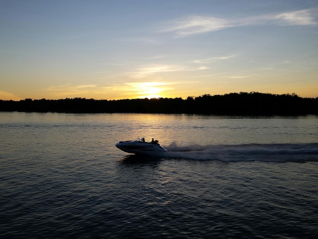 People in motorboat against sky