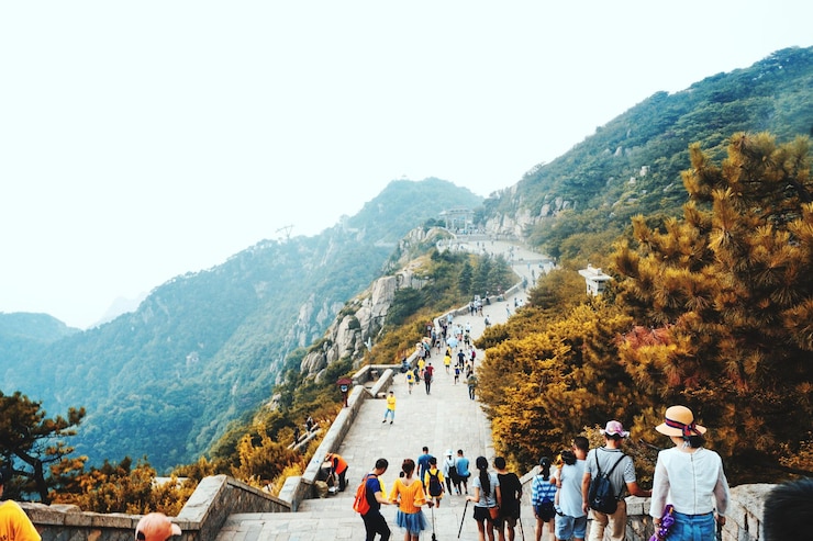Photo 明るい空を背景に山の道を歩く人々