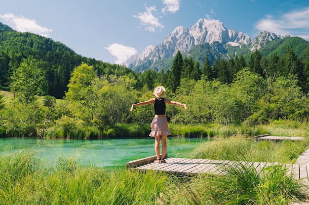 People in nature Tourist woman with raised arms up in green nature background