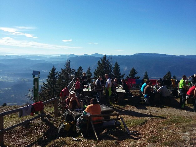 People at observation point by mountains against sky