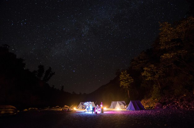 写真 夜の空に照らされた野原の人々