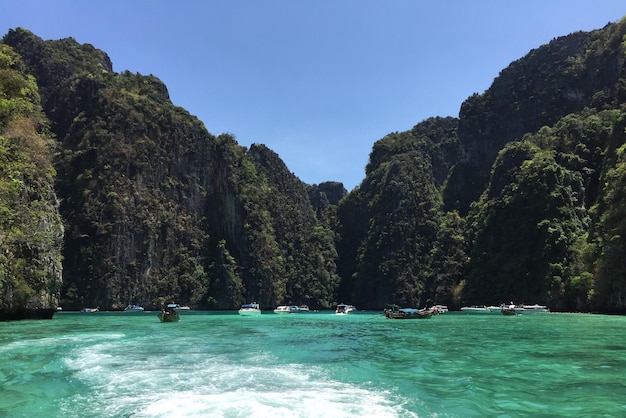 写真 青い空を背景に海の岩の上にいる人々