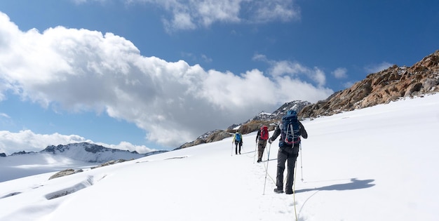 写真 空に逆らって雪に覆われた山の上にいる人々