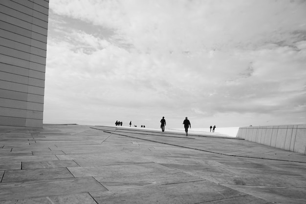 Foto persone all'opera di oslo contro un cielo nuvoloso