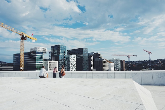 Photo people on oslo opera house against sky in city