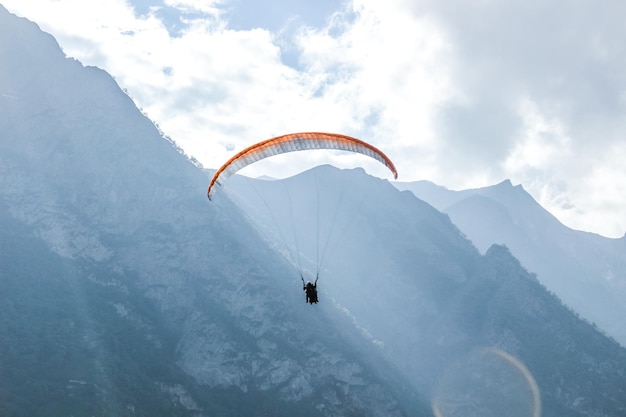 People paragliding on mountain peak against sky