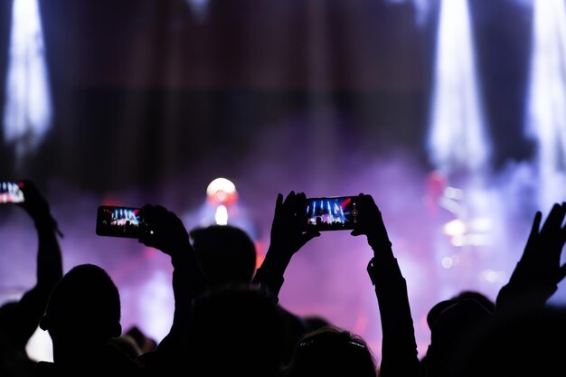 写真 音楽コンサートで写真を撮っている人々