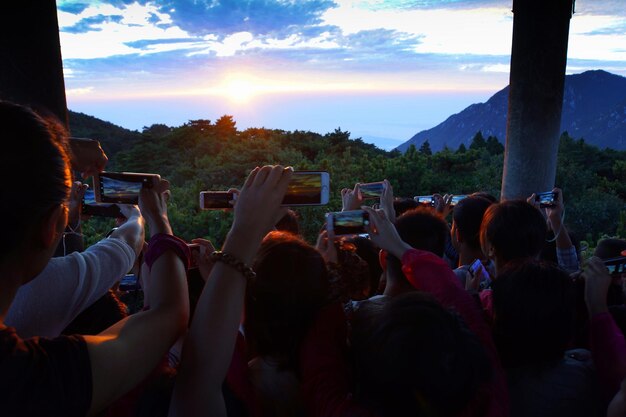 Photo people photographing at sunset