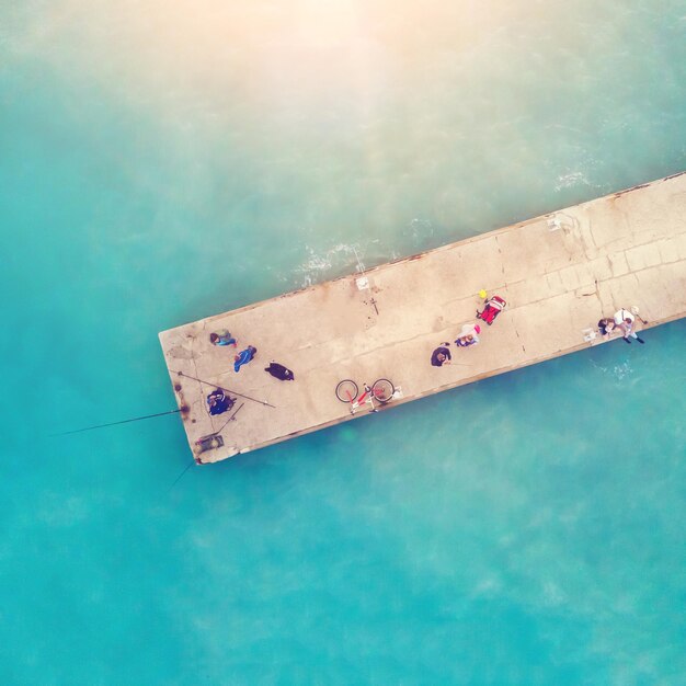 People on the pier in the sunlight top view