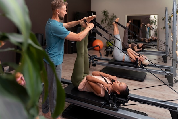 People in pilates reformer class exercising their bodies