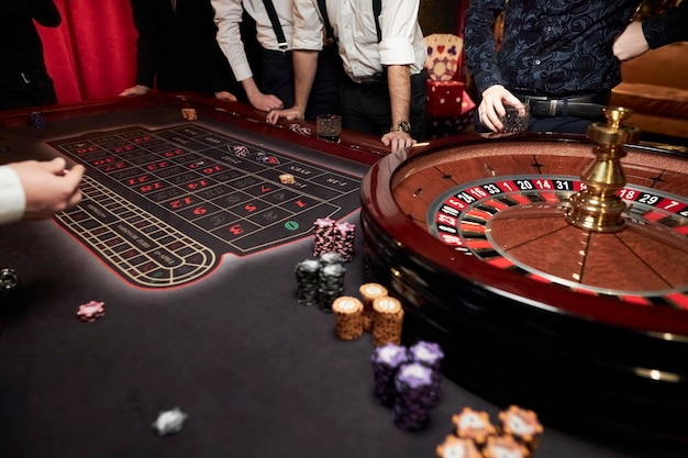 Фото Люди играют в покер рулетку за столом друзья играют в казино азартные игры казино рулетка