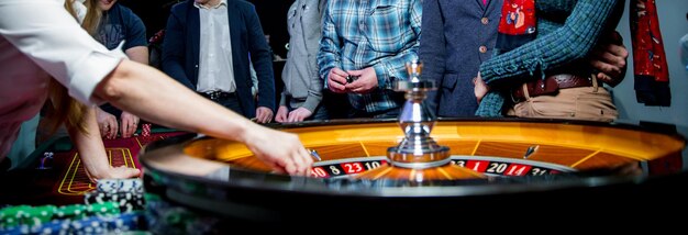 Foto la gente gioca alla roulette del poker al tavolo amici che giocano al casinò