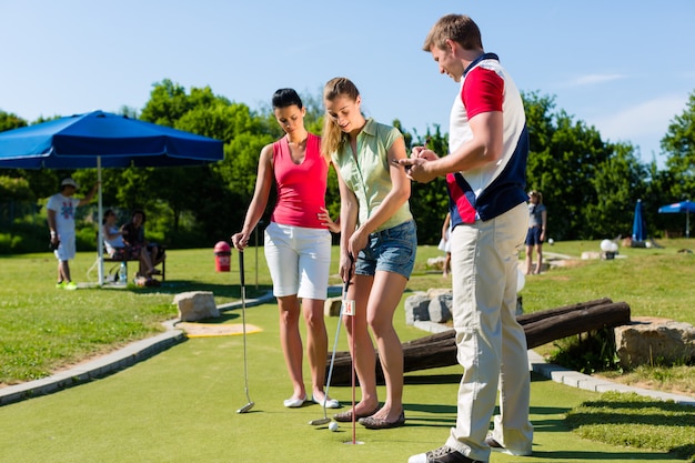 People playing miniature golf outdoors