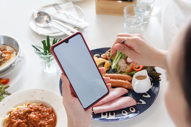 사진 아침 식사를 하면서 스마트폰을 사용하는 사람들이 텍스트를 추가하기 위해 색 공간을 사용합니다.