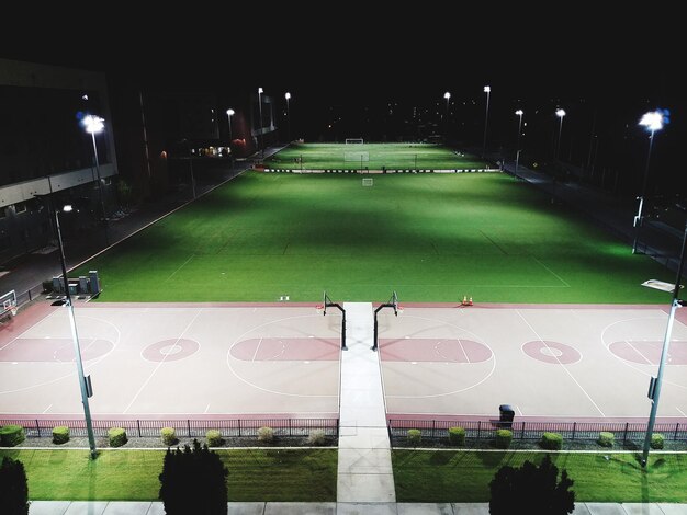 밤에 축구장 에서 축구 를 하는 사람 들