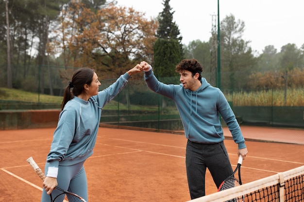 People playing tennis game in winter time