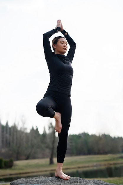 Foto persone che praticano yoga all'esterno