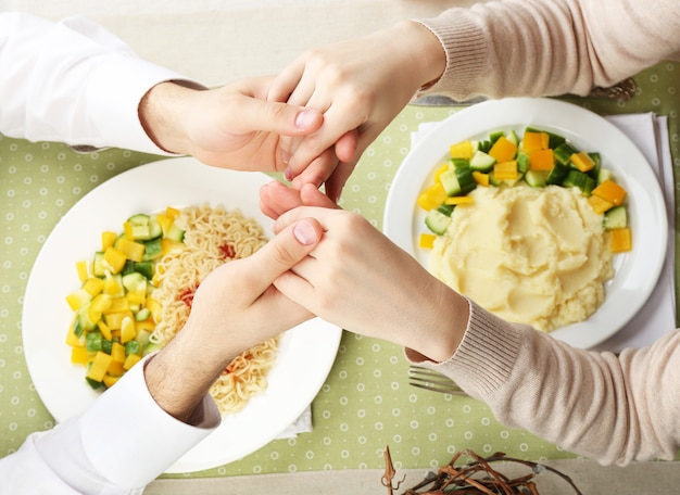 People praying before eating, top view