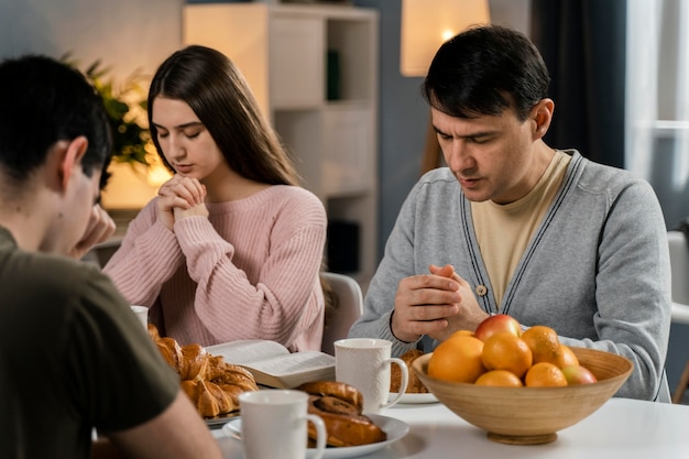 Foto persone che pregano insieme prima di cena