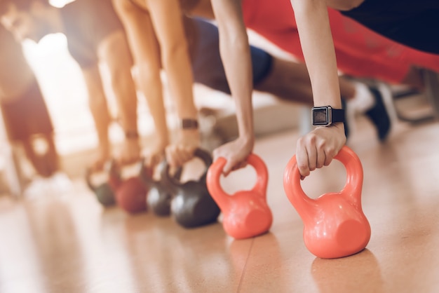 People push up on the dumbbells in the gym