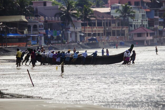 Photo people pushing boat in sea