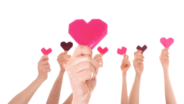 People putting hands in air together with little hearts on white background Volunteering concept