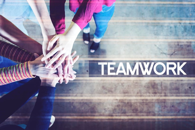 People putting hands together near teamwork word