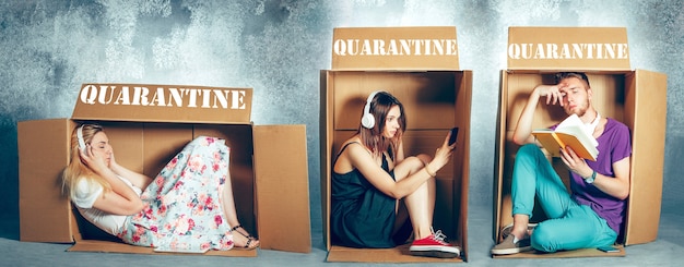 Photo people at quarantine of coronavirus spreading - sitting inside little boxes, staying home concept. men and women trying to have activity while keeping isolation. prevention of flu virus pandemic.