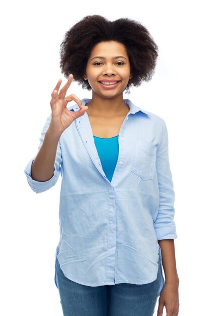 people, race, ethnicity, gesture and portrait concept - happy african american young woman showing ok hand sign over white