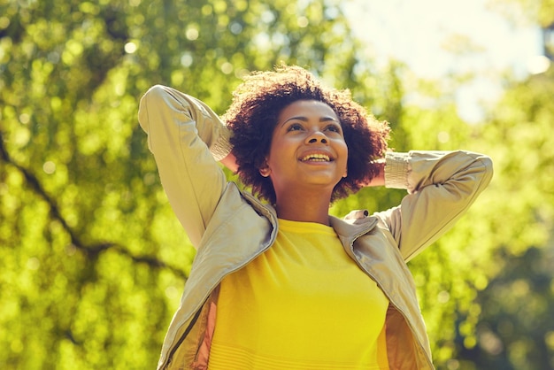 Photo people, race, ethnicity and portrait concept - happy african american young woman in summer park