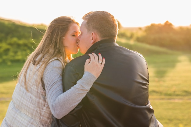 人、関係、感情の概念-秋の公園でキスを愛する若いカップル