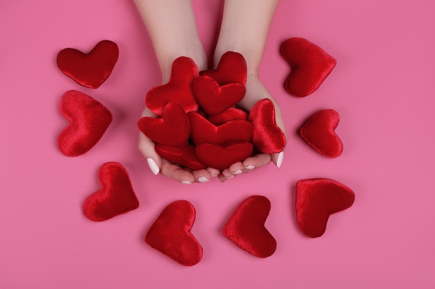 People, relationship and love concept - close up of womans cupped hands showing red heart