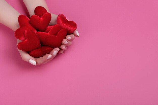 People, relationship and love concept - close up of womans cupped hands showing red heart