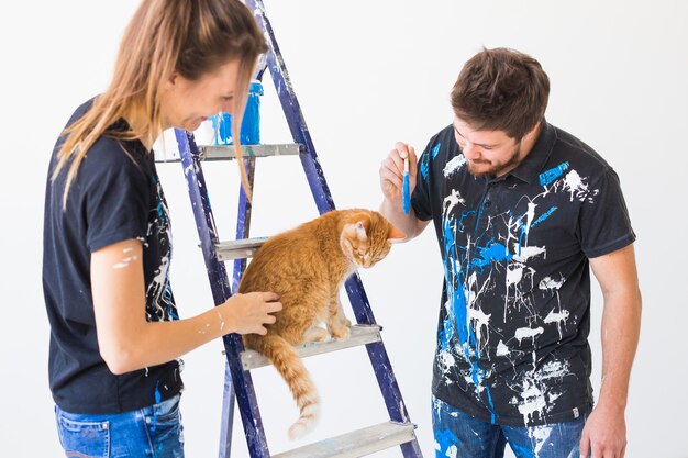 사람, 혁신, 애완 동물 및 수리 개념-재미 있은 남자와 여자의 초상화 고양이 아파트에서 재 장식을하고