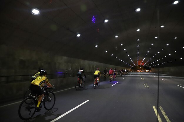 写真 照らされたトンネルで道路で自転車に乗っている人々