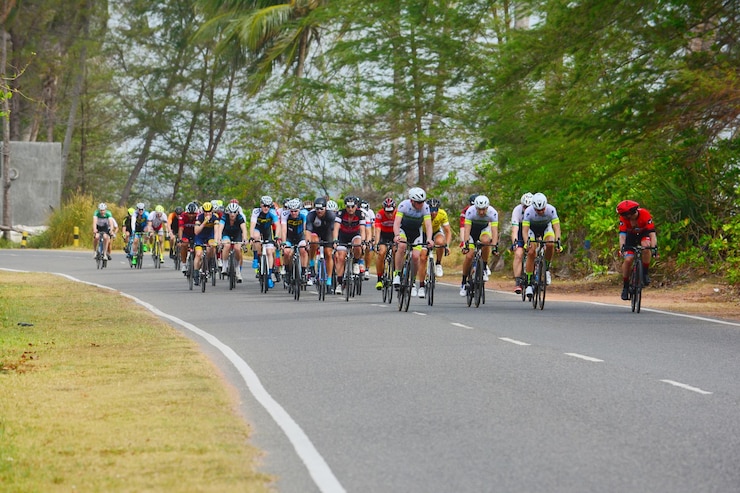 Photo 樹木にぶつかる道路で自転車に乗っている人々