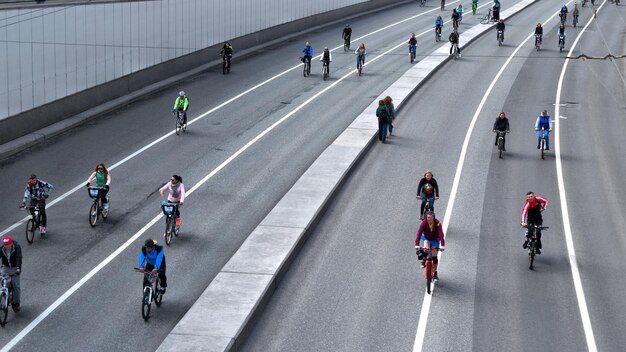 Photo people riding bicycles on road in city