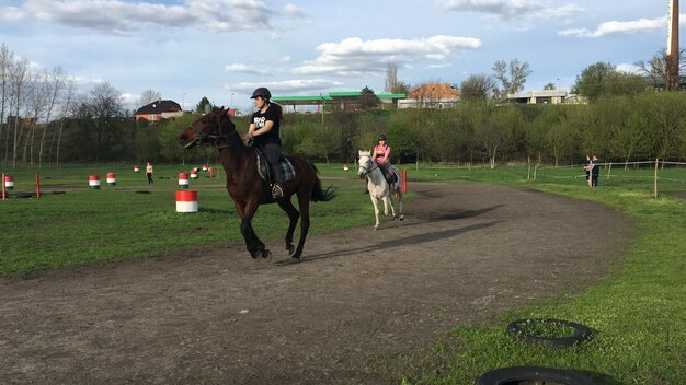 Foto persone in moto sul campo contro il cielo