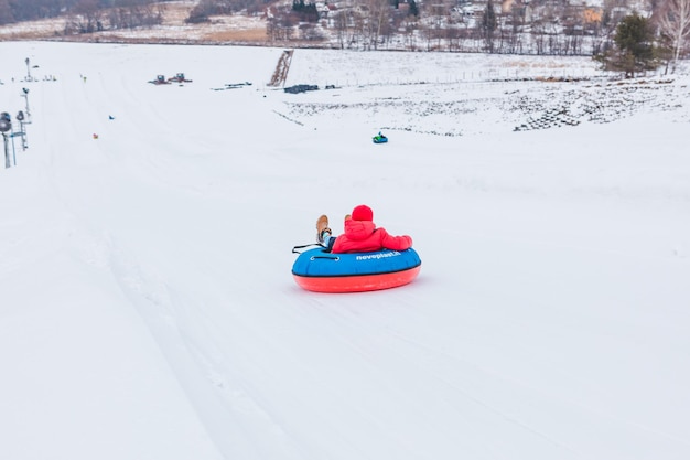 People riding snow tubing at winter park copy space