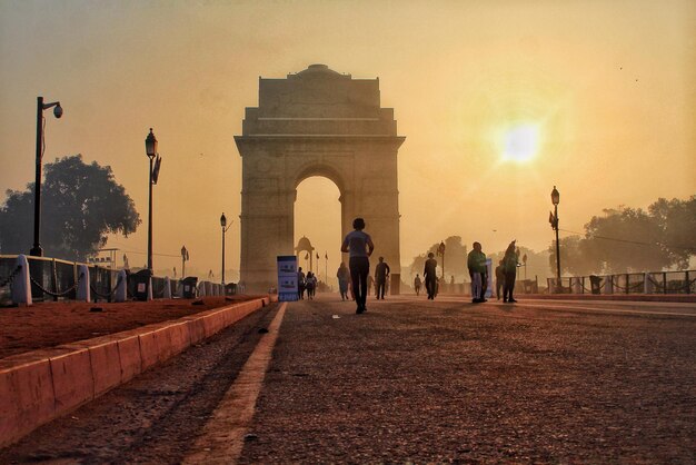 Photo people on road against gate during sunset