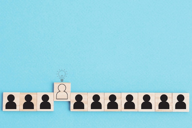 Photo people in row and one different human with idea lamp over his head on blue background