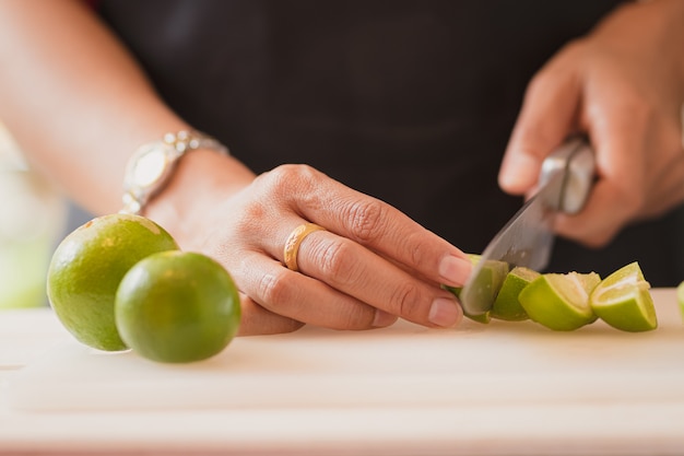 Photo people's hands cutting lemon .