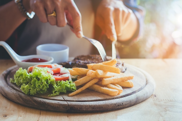 おいしいステーキを楽しく食べる人の手