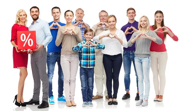 people, sale, discount and shopping concept - happy people with red percentage sign showing heart shape