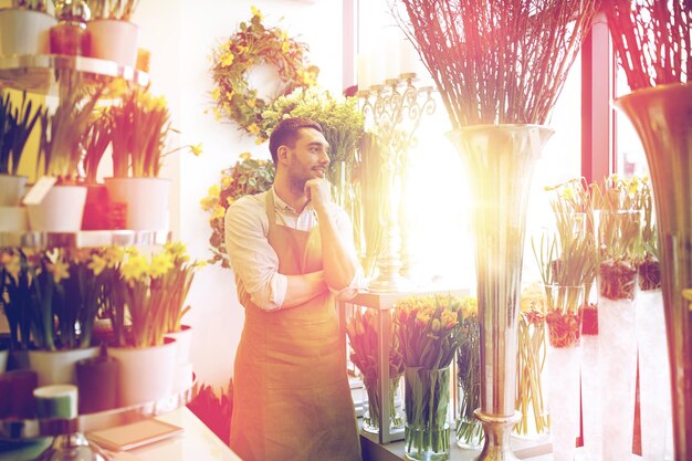 사람, 판매, 소매, 비즈니스 및 플로리스트 개념 - 꽃집에 현금 상자가 서 있는 행복한 웃는 꽃집 남자