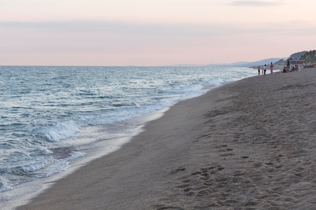 Foto persone in riva al mare al tramonto